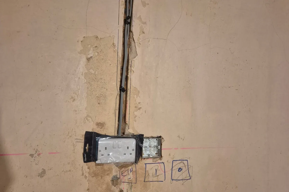 New double socket being fitted on a chased wall during a rewire