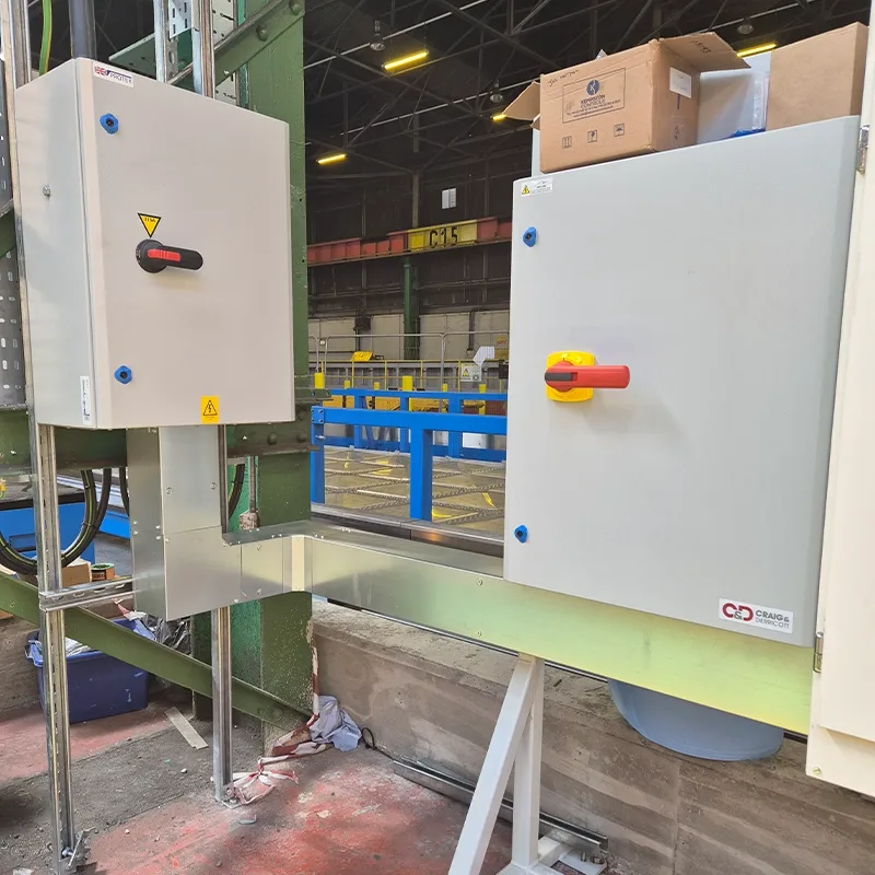 Industrial isolator enclosures installed beside a plant conveyor