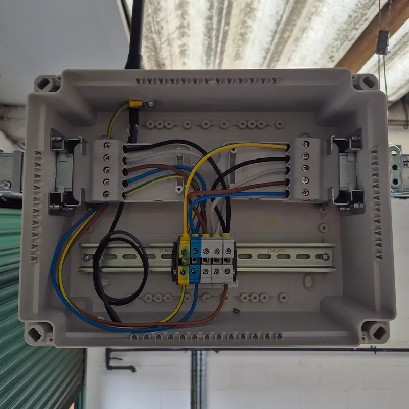 Weatherproof control enclosure with DIN-rail terminals wired in a warehouse