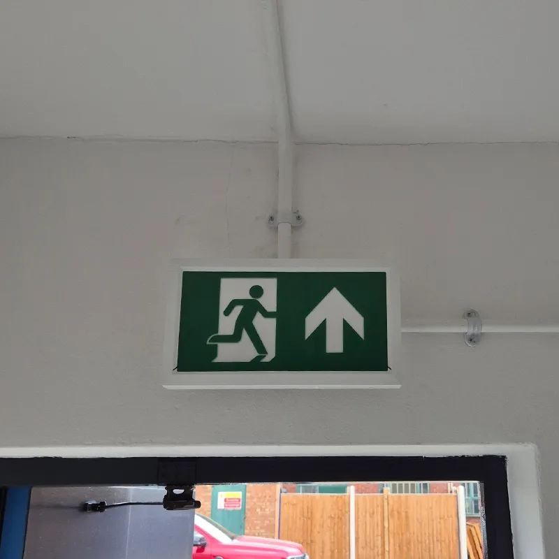 Illuminated emergency exit sign installed above a doorway